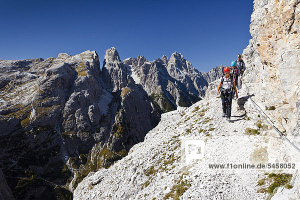Mountaineers in the Alpinisteig fixed rope route on Mt Einser  Mt Dreischusterspitze at back  Hochpustertal Valley  Sexten  Dolomites  South Tyrol  Italy  Europe