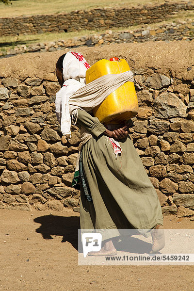 Woman carrying water from Queen of Sheba's Swimming Pool  Aksum  Ethiopia  Africa