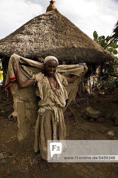 Alte Frau steht vor einer Hütte in der Nähe von Bilbilla Chirkos  Lalibela  Äthiopien  Afrika