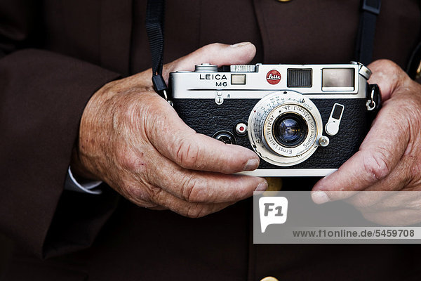 Hände eines alten Mannes hält Leica Kompaktkamera in seinen Händen  Nordtirol  Österreich  Europa