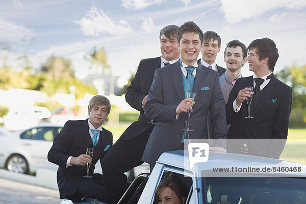 Teenager Jungen in Anzügen lächeln aus dem Auto