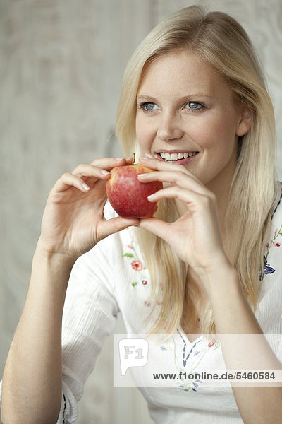 Blonde Frau mit einem Apfel