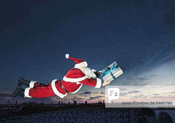 Weihnachtsmann fliegend mit verpacktem Geschenk