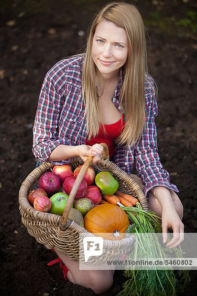 Frau sammelt Gemüse im Garten