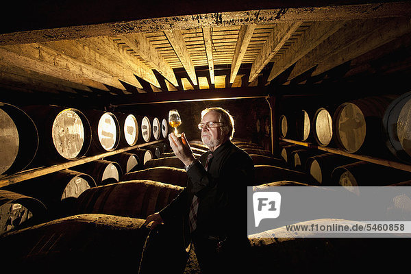 Arbeiter testen Whisky in der Destillerie