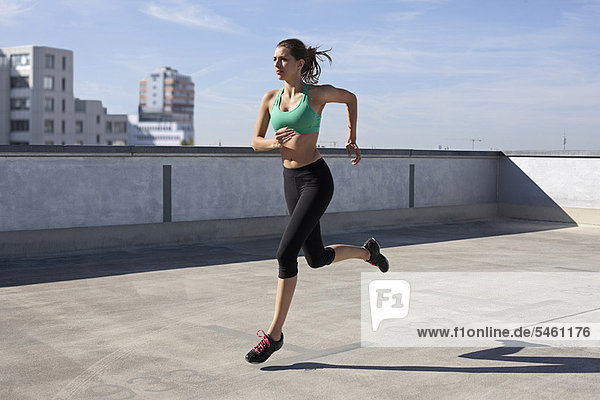 Frau beim Joggen auf dem Dach
