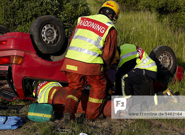 Feuerwehrleute retten Menschen aus abgestürzt Auto