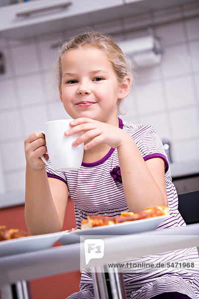 Young girl having breakfast in the kitchen