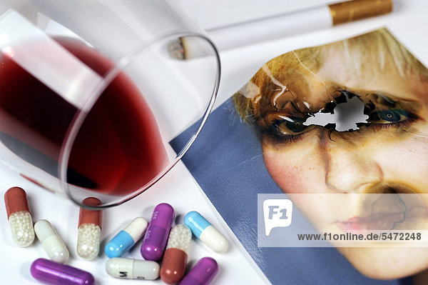 Angebranntes Foto  umgekipptes Weinglas  Zigarette und Kapseln  Symbolbild Burnout-Syndrom