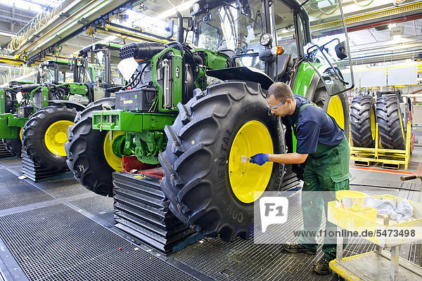 Wheels are given a coat of paint in the tractor production section at the European headquarters of the American agricultural machinery manufacturer John Deere  Deere & Company  Mannheim  Baden-Wuerttemberg  Germany  Europe