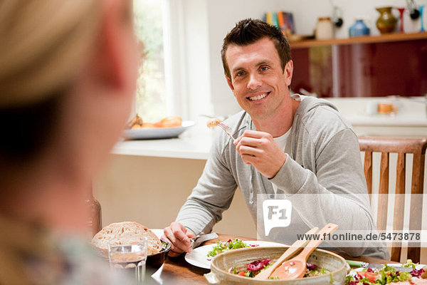 Couple eating healthy meal together at table