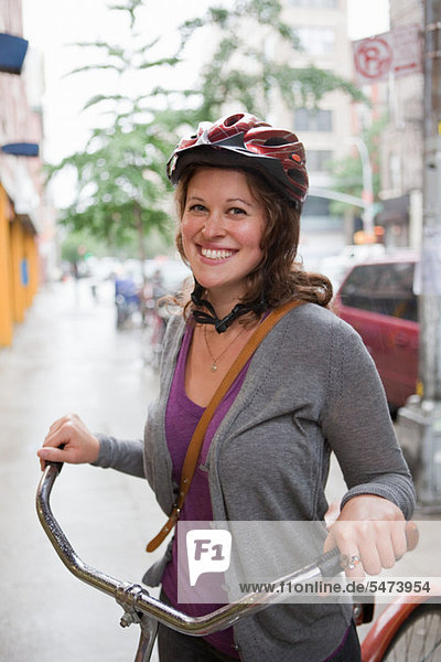Junge Frau tragen Zyklus Helm  lächelnd