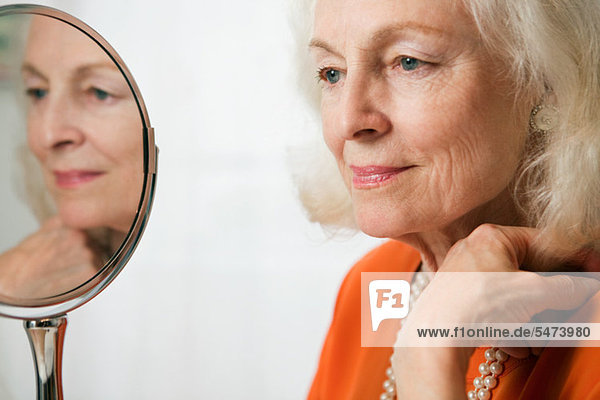 Seniorin mit Reflektion im Spiegel