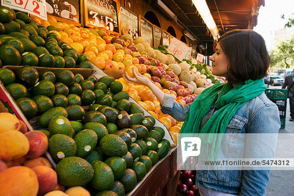 Junge Frau beim Einkaufen am Marktstand
