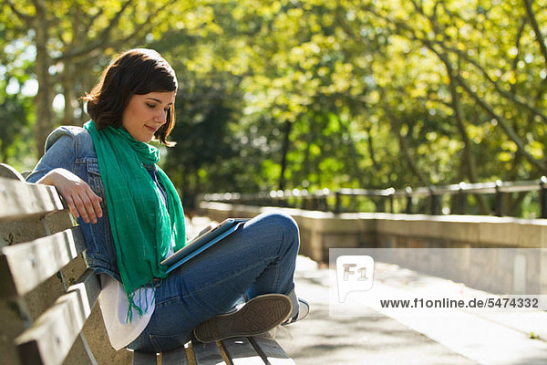 Junge Frau beim Lesen im Park