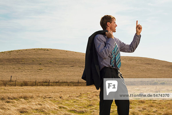 Mann beim Vermessen der Landschaft mit dem Finger in der Luft