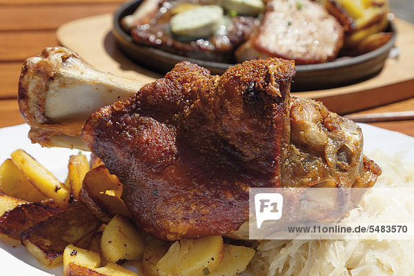 Gegrillte Schweinshaxe mit Röstkartoffeln und Sauerkraut