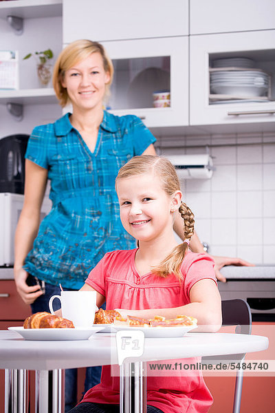 Mutter und Tochter beim Frühstück in der Küche
