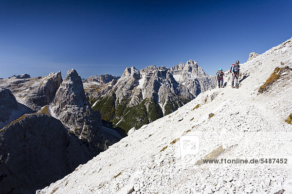 Wanderer im Alpinisteig  Blick auf den Einser  hinten die Dreischusterspitze  unten das Fischleintail  Sexten  Hochpustertal  Dolomiten  Südtirol  Italien  Europa