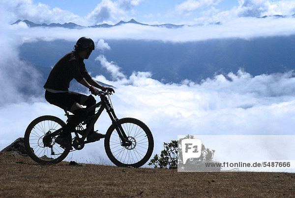 Downhill biker  high above the clouds  Camino de la muerte  death road  La Paz  Bolivia  South America