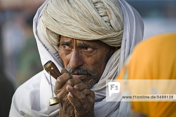 Man wearing a white turban with a chilam pipe  portrait  Jaipur  Rajasthan  India  Asia