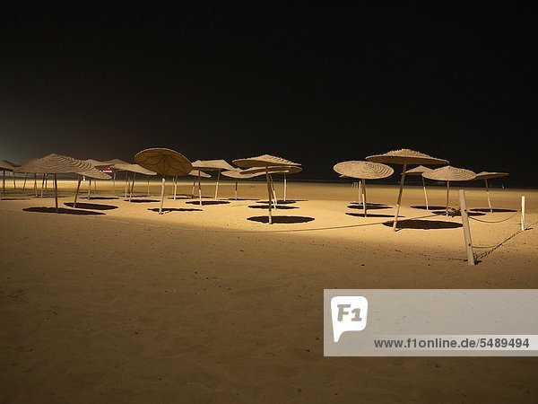 Marokko  Essaouira  Sonnenschirme am Strand bei Nacht