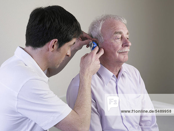 Germany  Hamburg  Doctor examining patient with Otoscope