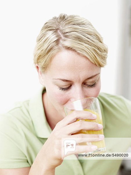 Mid adult woman drinking juice