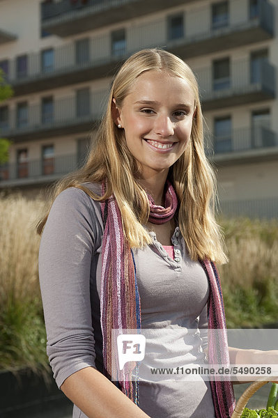Teenage girl with basket  smiling  portrait