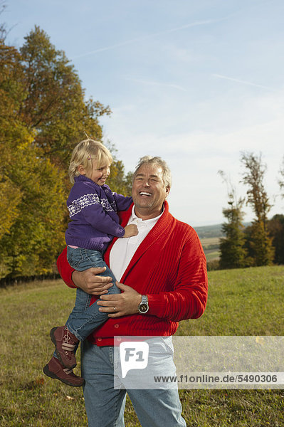 Deutschland  Bayern  Großvater mit Enkelin  lächelnd
