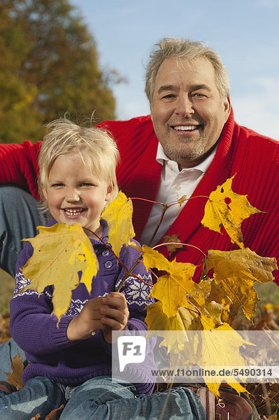 Deutschland  Bayern  Großvater und Enkelin im Herbst  Portrait  lächelnd