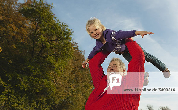 Deutschland  Bayern  Großvater und Enkeltöchter spielen  lächelnd