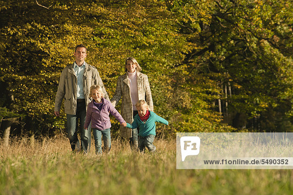 Germany  Bavaria  Family walking in meadow during autumn