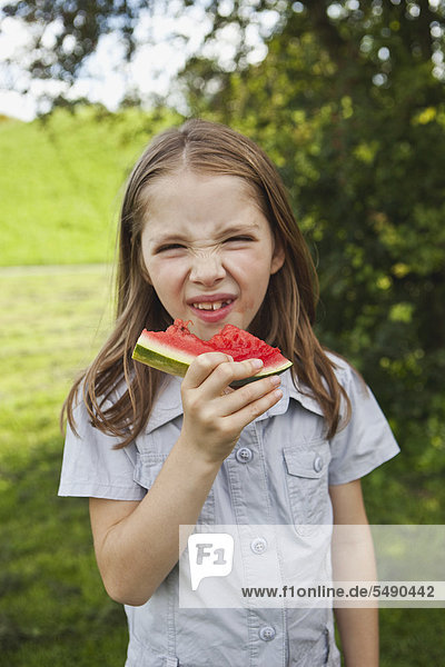 Girl eating watermelon in park  portrait