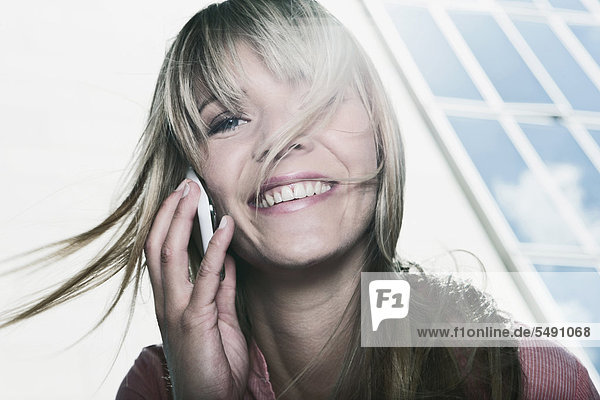 Junge Frau mit Handy  lächelnd  Portrait
