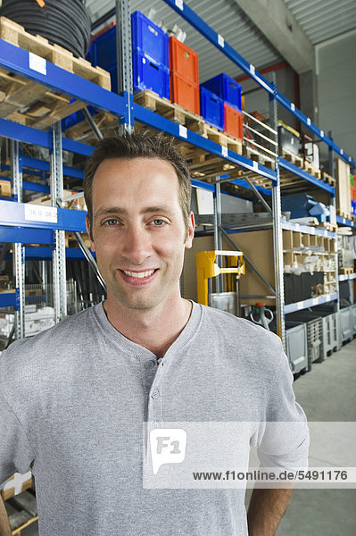 Germany  Bavaria  Munich  Manual worker in warehouse  smiling  portrait