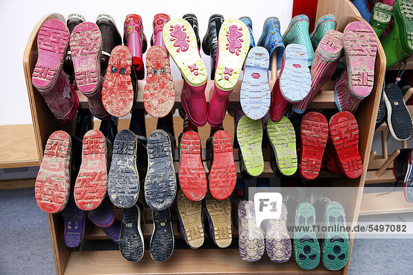 Boot rack with wellington boots lined up to dry in an all-day nursery Boot rack with wellington boots, lined up to dry, in an all-day nursery