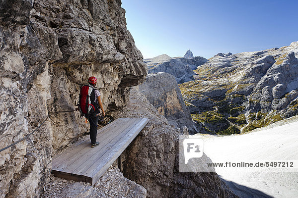 Mountaineer standing on Alpinisteig trail  the Tre Cime di Lavaredo peaks at the back  Sexten  Hochpustertal valley  Dolomites  province of Bolzano-Bozen  Italy  Europe