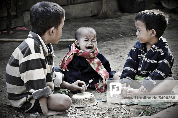 Crying baby and two boys in Laos  Southeast Asia  Asia