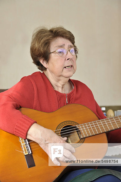Seniorin spielt Gitarre