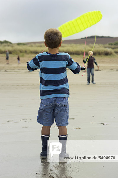 Ein Junge lässt am Atlantikstrand einen Lenkdrachen fliegen  Finistere  Bretagne  Frankreich  Europa  ÖffentlicherGrund