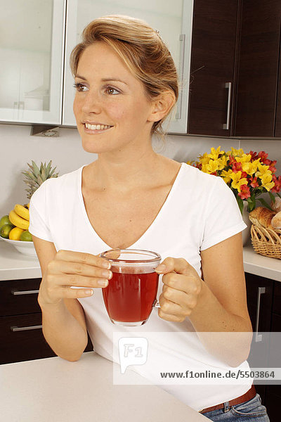 Frau In der Küche Obst Tee trinken