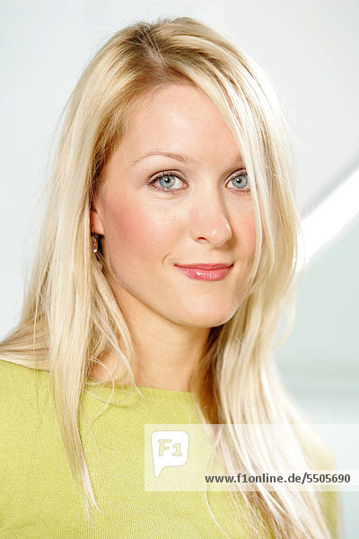 Portrait of young Business Frau mit dem langen blonden Haaren tragen grünen Pullover