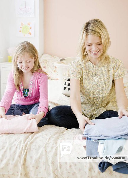 Mutter und Tochter Falten Kleidung