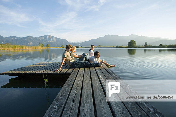 Two couples relaxing on a pier.