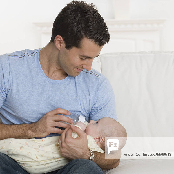 Vater Fütterung Baby auf sofa