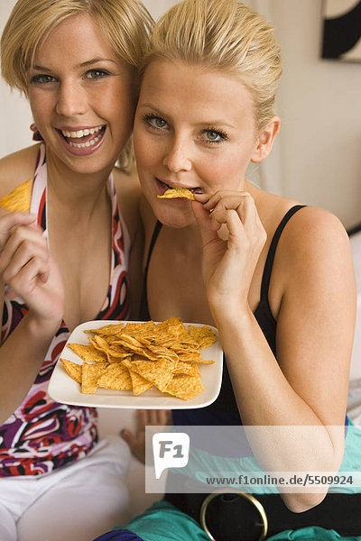 Junge Frauen essen Kartoffelchips