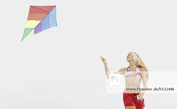 Junge Frau fliegender Kite am Strand