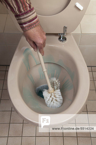 Mann reinigt Toilette