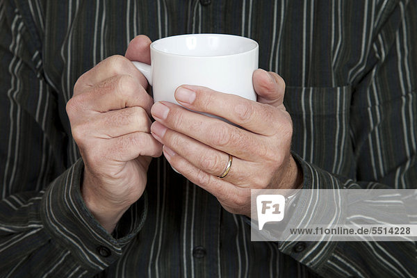 Männerhände halten Kaffeetasse